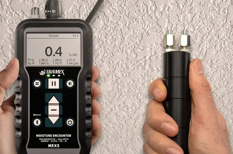 Pin and pinless moisture meters checking a textured wall for water damage
